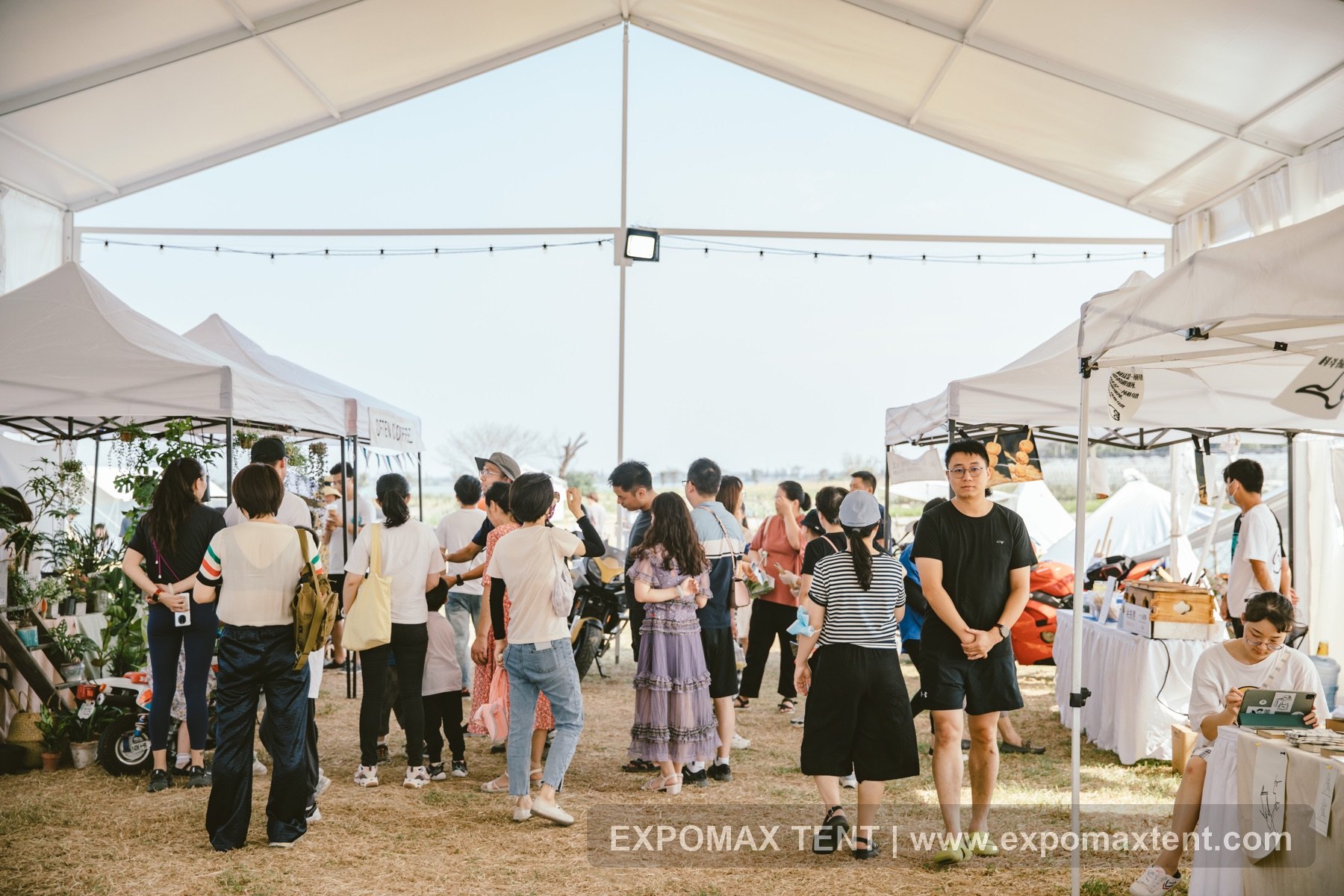 Vendor crowd under party tent at Wujiang lawn market