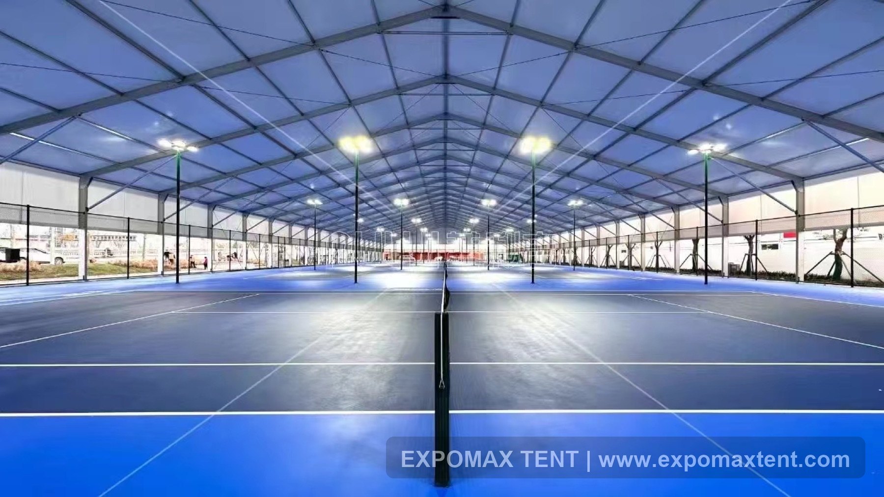 Large clear-span tennis courts inside a tent venue