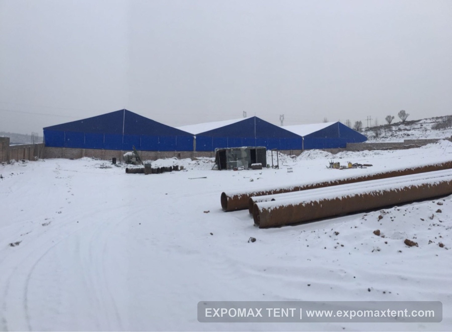 Blue warehouse tents in snowy field